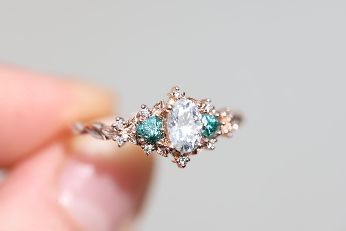 Briar rose three stone with oval moissanite and teal moissanite side stones