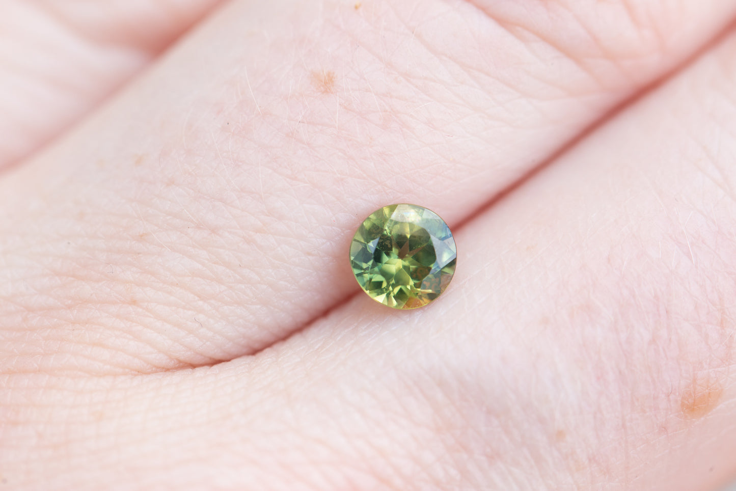 .83ct round green with a little yellow sapphire