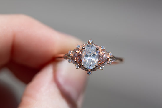 Woodland three stone setting with oval 7x5mm moissanite and lab peach sapphire sides