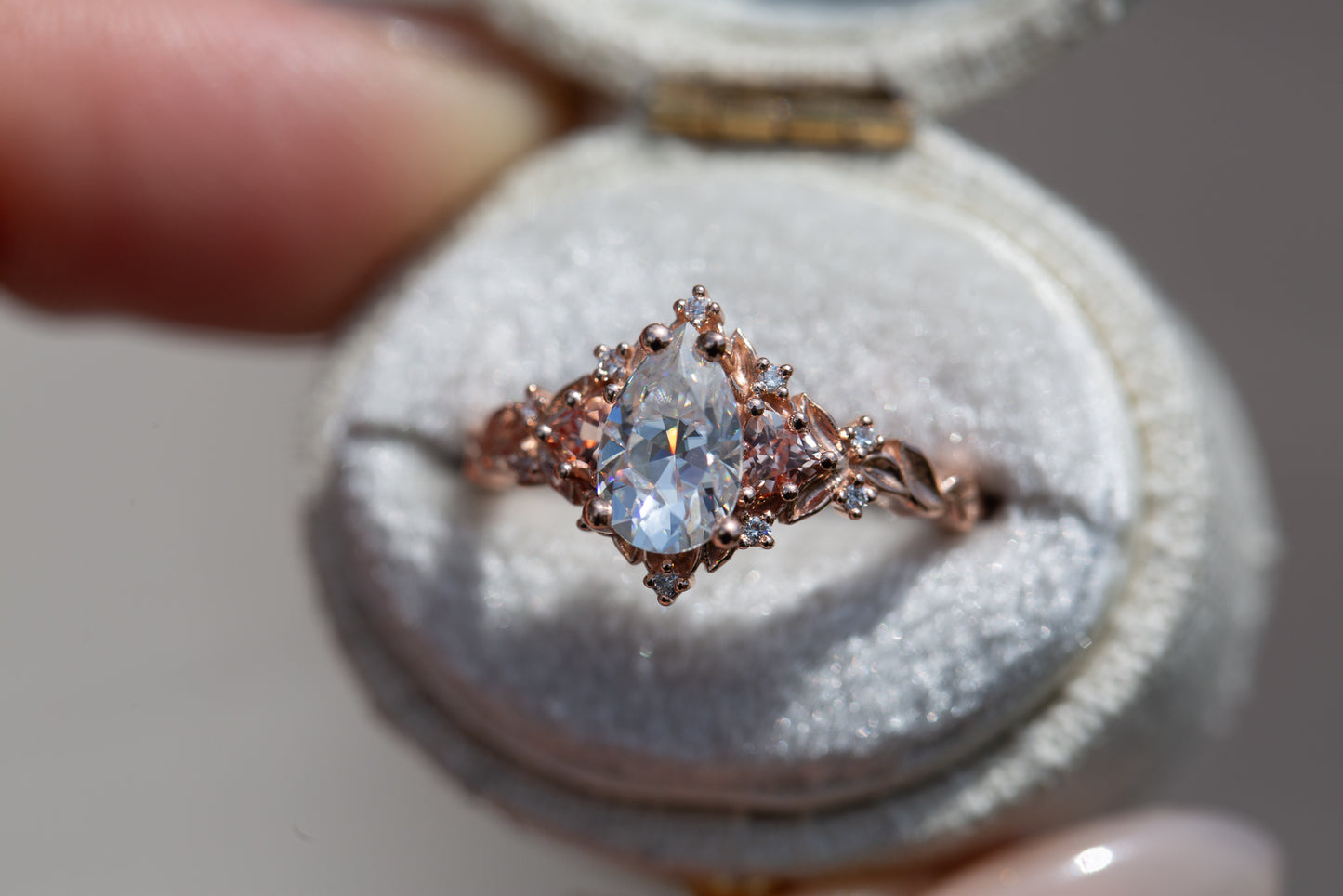 Briar rose three stone with 8x5mm pear moissanite center and lab peach sapphires