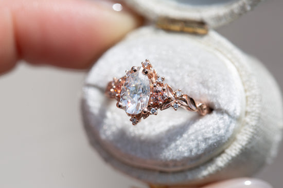 Briar rose three stone with 8x5mm pear moissanite center and lab peach sapphires