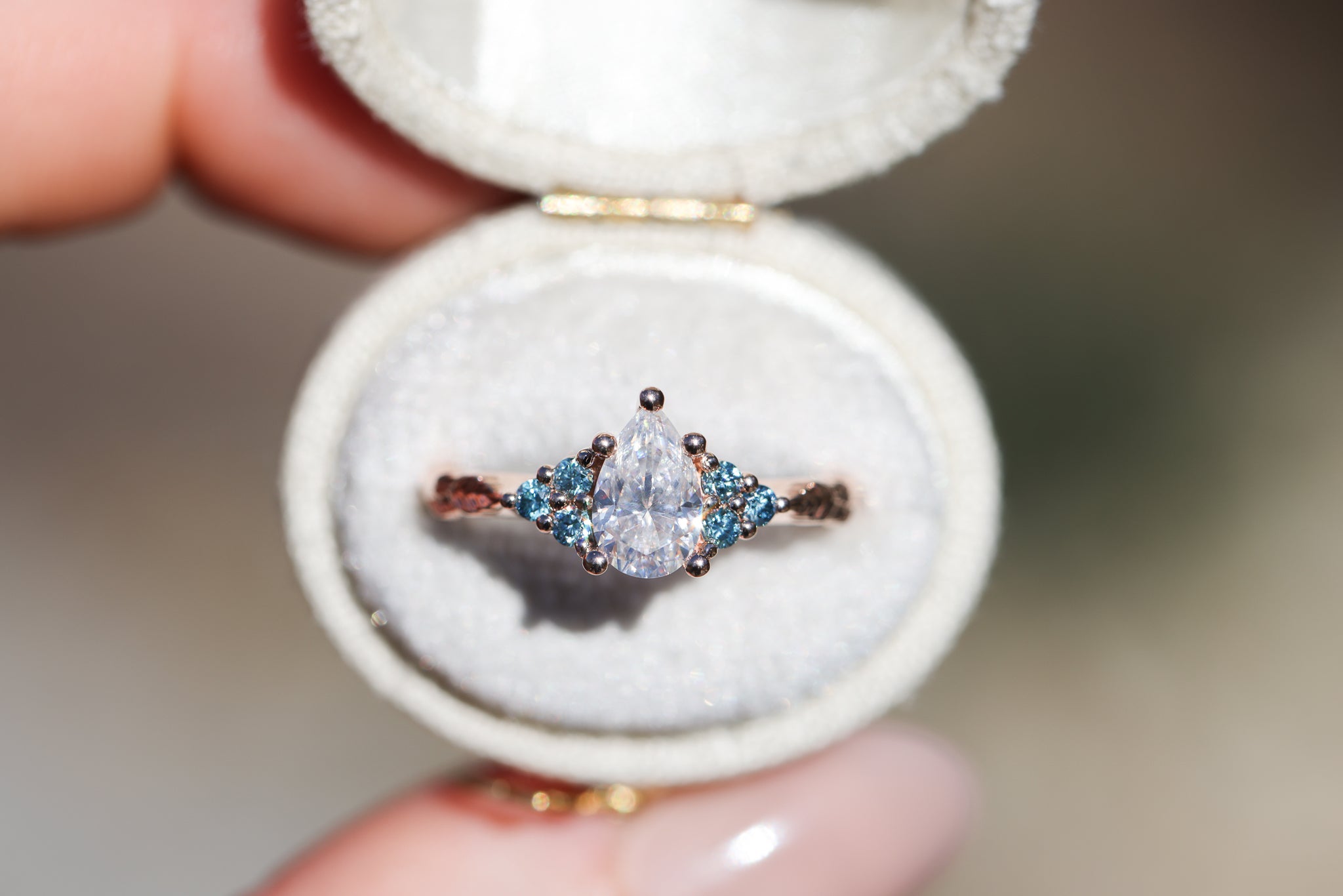 Seraphina with pear moissanite center and aqua irradiated diamonds