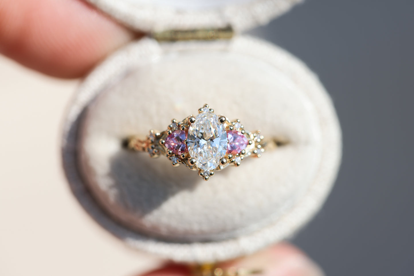 Briar rose three stone with oval lab diamond center and lab pink sapphire sides