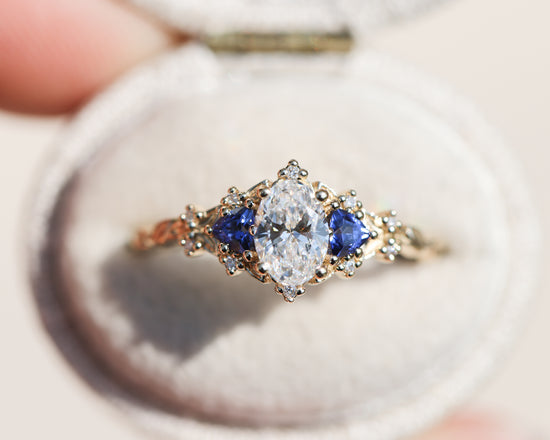 Briar rose three stone with oval lab diamond center and lab blue sapphire sides