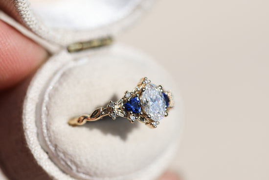 Briar rose three stone with oval lab diamond center and lab blue sapphire sides