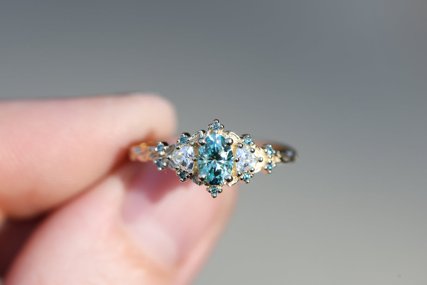 Briar rose three stone with oval teal moissanite and aqua diamonds