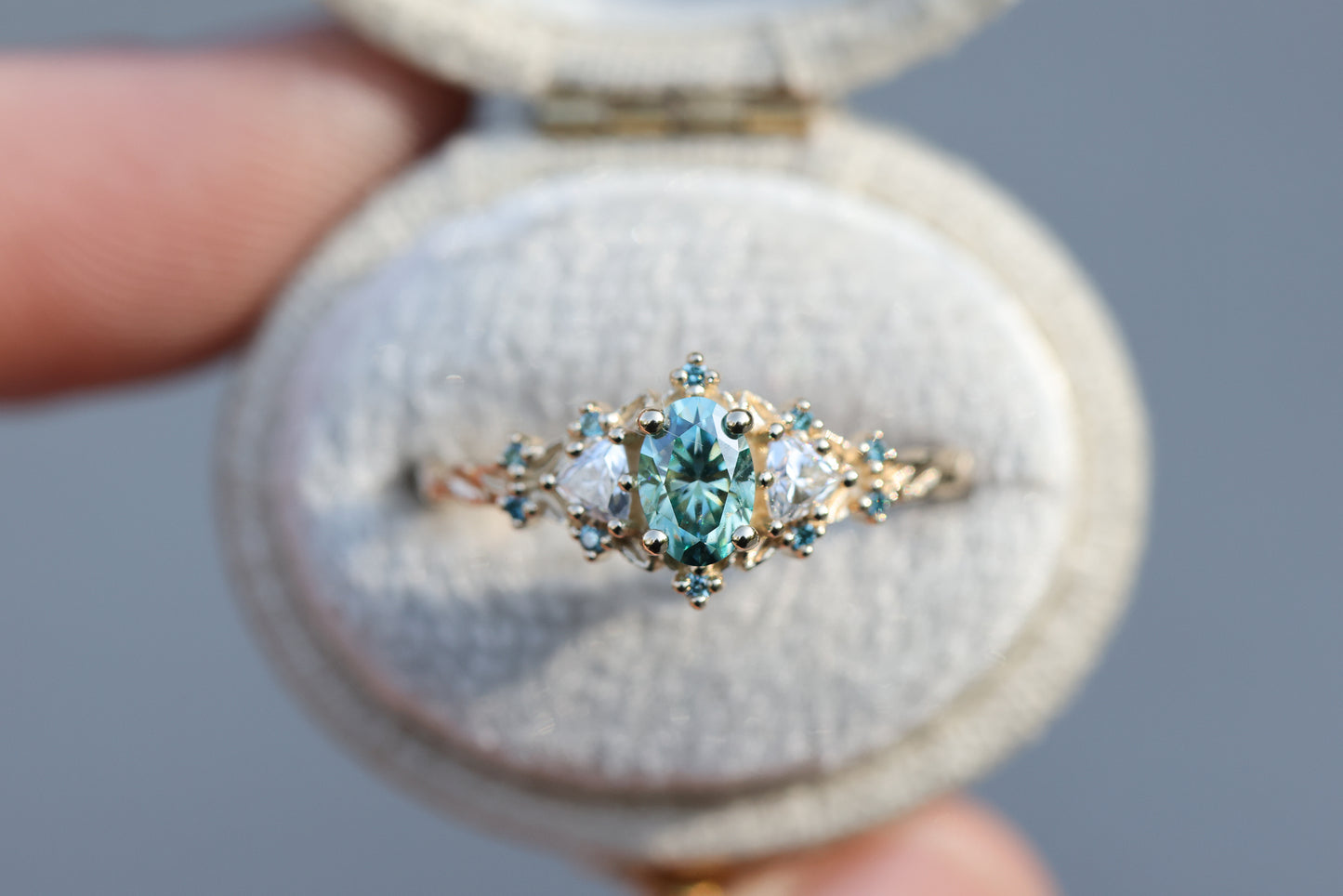 Briar rose three stone with oval teal moissanite and aqua diamonds