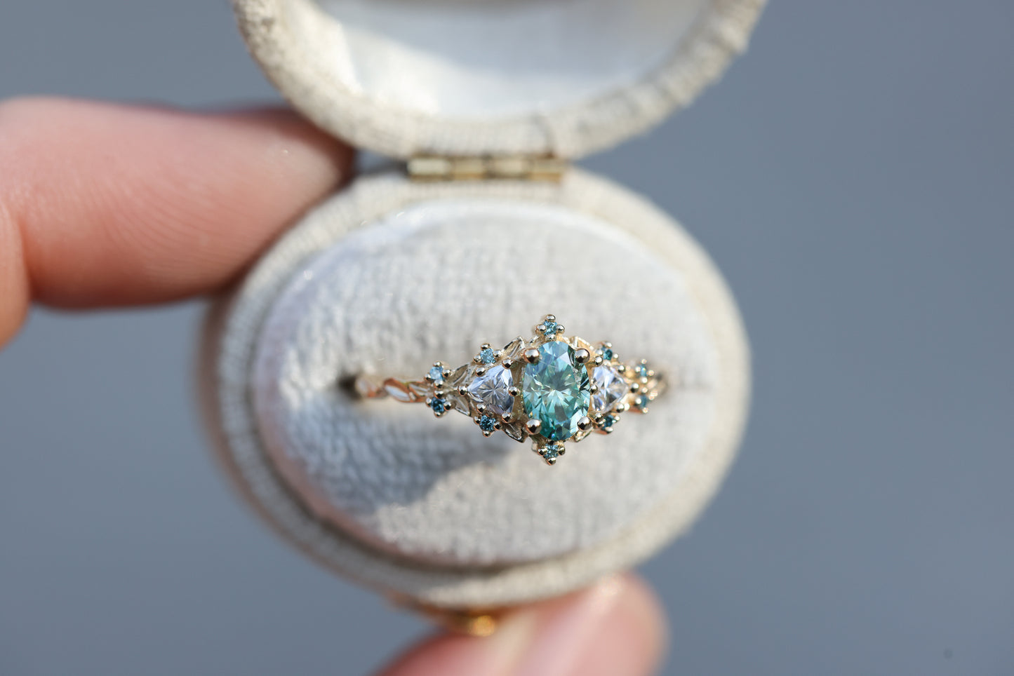 Briar rose three stone with oval teal moissanite and aqua diamonds