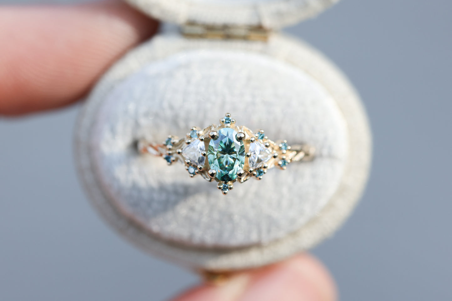 Briar rose three stone with oval teal moissanite and aqua diamonds