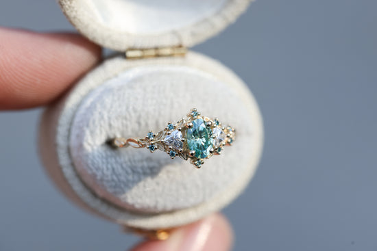 Briar rose three stone with oval teal moissanite and aqua diamonds