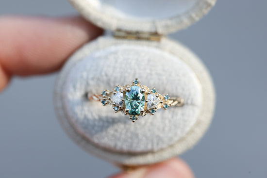 Briar rose three stone with oval teal moissanite and aqua diamonds