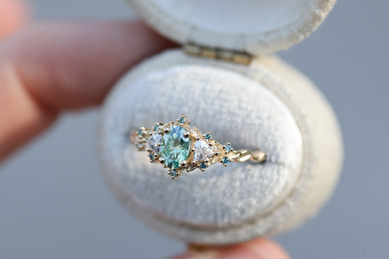 Briar rose three stone with oval teal moissanite and aqua diamonds