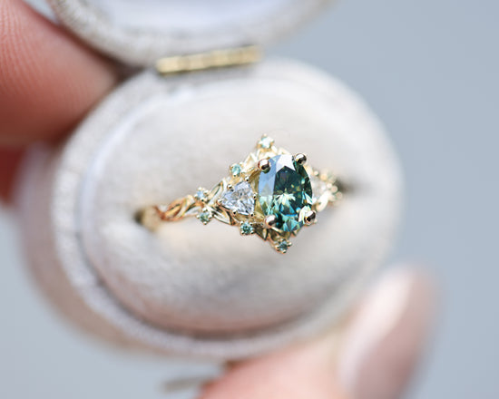 Briar rose three stone with 7x5mm oval teal moissanite center