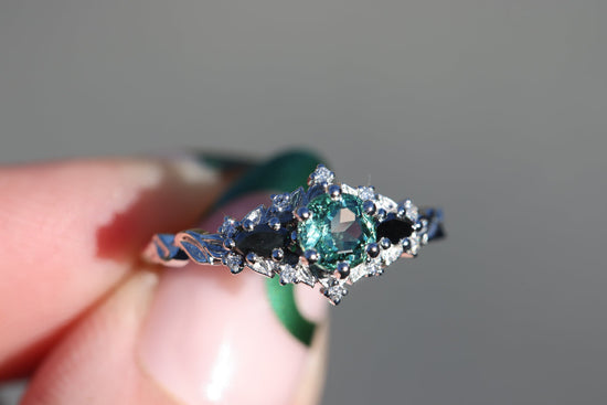 Briar rose three stone with round lab green sapphire center and black diamonds