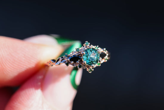 Briar rose three stone with round lab green sapphire and black diamond sides and accents