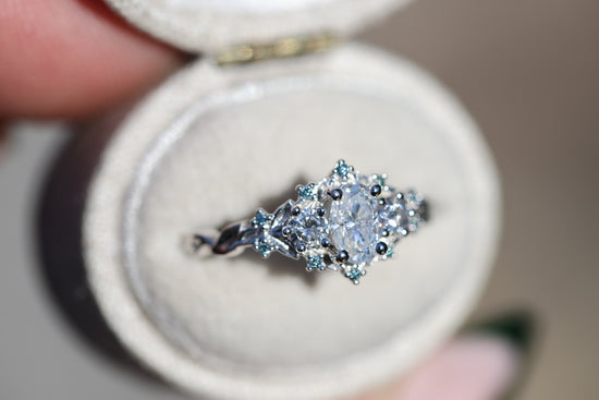 Briar rose three stone with oval moissanite and aqua irradiated diamond accents