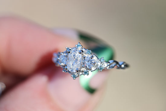 Briar rose three stone with oval moissanite and aqua irradiated diamond accents