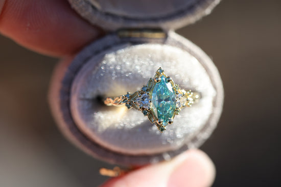 Briar Rose Three Stone with 10x5mm marquise teal moissanite, mint diamond accents