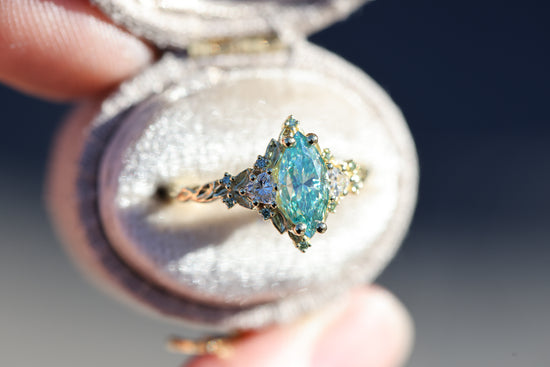 Briar Rose Three Stone with 10x5mm marquise teal moissanite, mint diamond accents