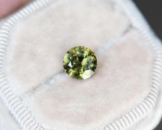Load image into Gallery viewer, 2.6ct round olive green salt and pepper sapphire
