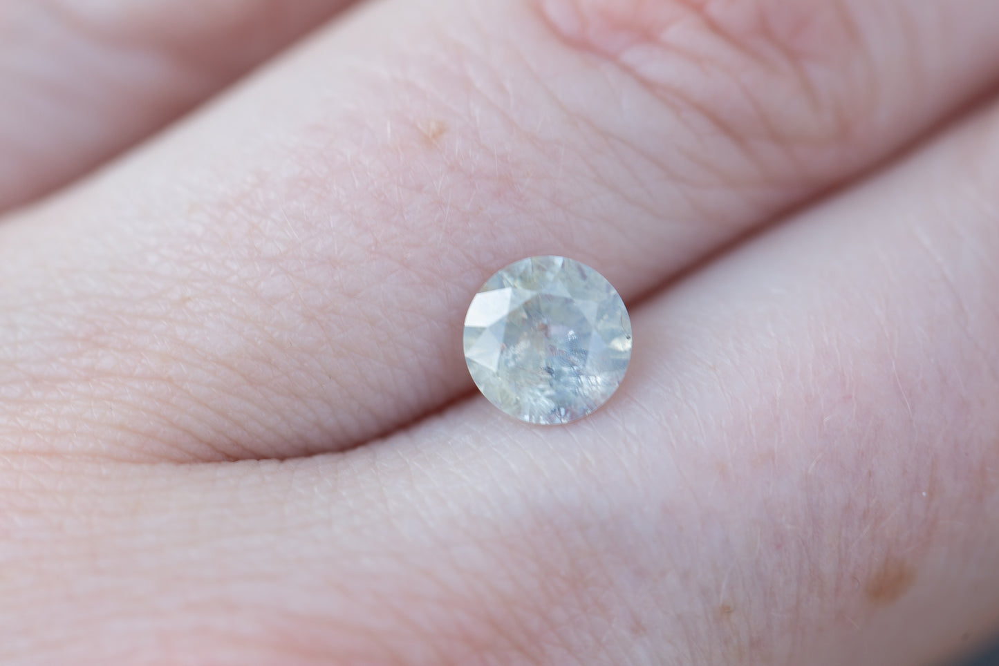 1.47ct round opalescent very pale teal/white sapphire